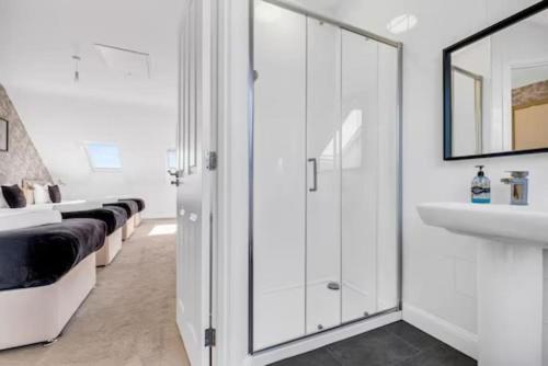 a white bathroom with a sink and a mirror at City Centre 3 Bedroom House Sleep upto 9 Guests with Garden and Parking in Birmingham