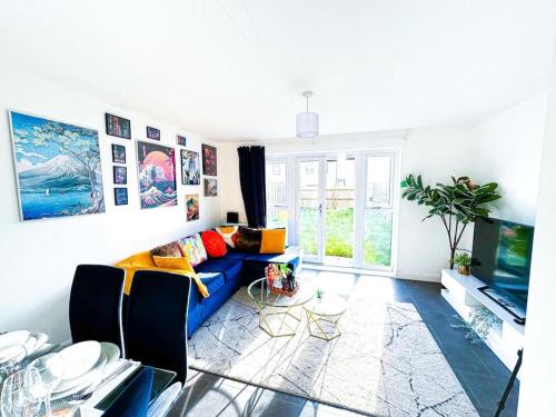 a living room with a blue couch and a tv at City Centre 3 Bedroom House Sleep upto 9 Guests with Garden and Parking in Birmingham