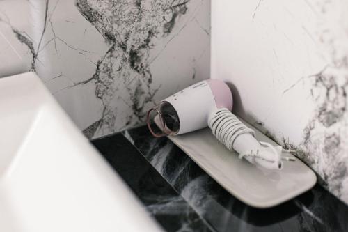 a hair dryer sitting on the corner of a bathroom at Villa Obsidian, sea view and walk to Choeng Mon beach in Choeng Mon Beach
