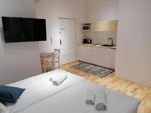 sypialnia z białym łóżkiem i kuchnią w obiekcie Juwel Apartments Kraków 14 w Krakowie