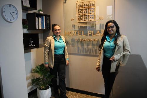 two people are standing in a room with a clock at Hotel Plaza El Santuario in Santuario