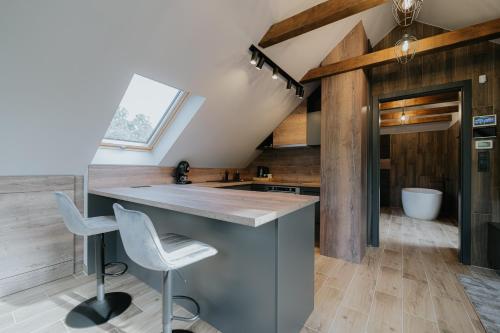 a kitchen with a counter and two stools at Castle Inn - Szabadkígyós in Szabadkígyós