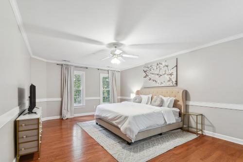 クレイトンにあるBright Clayton Home with Screened Deck!の白いベッドルーム(ベッド1台、天井ファン付)