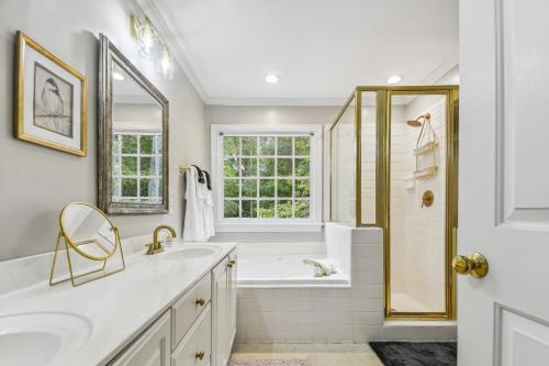 baño con bañera, lavabo y ventana en Bright Clayton Home with Screened Deck!, en Clayton