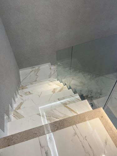 ポルト・ヴェーリョにあるSobrado no esperança da comunidadeの白い大理石フロアの客室で、ガラスの壁が特徴です。