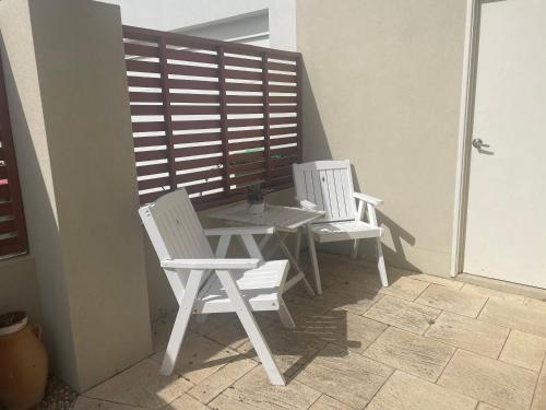 two white chairs and a table on a patio at Ocean Reef Retreat in Perth