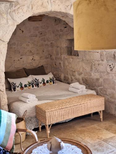 ein Schlafzimmer mit einem Bett in einer Steinmauer in der Unterkunft Residenza Anima Mediterranea in Francavilla Fontana