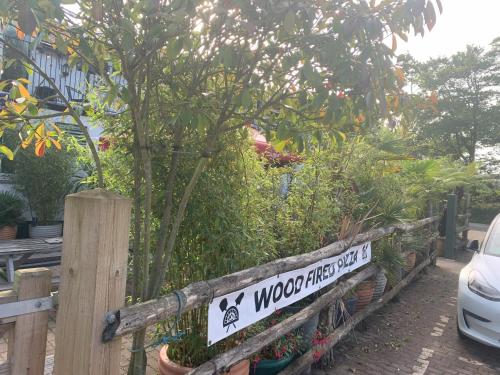 a sign on a wooden fence with plants at The Bickford Arms Inn in Holsworthy