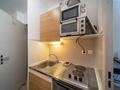 une petite cuisine avec un évier et un micro-ondes dans l'établissement Appartement tout équipé à 5 min de la gare St Charles, à Marseille