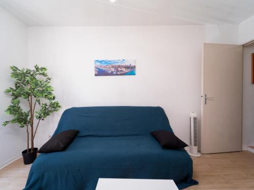 łóżko w białym pokoju z zielonym kocem w obiekcie Appartement tout équipé à 5 min de la gare St Charles w Marsylii