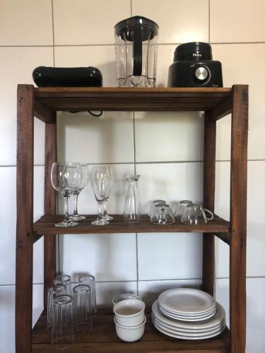 a wooden shelf with glasses and dishes on it at Chalé Tiririca Surf & Mar in Itacaré