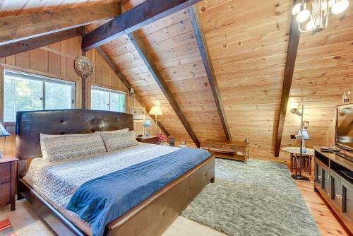 Waterfront Lake Arrowhead Cabin with Dock and Fire Pit في North Waterboro: غرفة نوم بسرير في غرفة بجدران خشبية