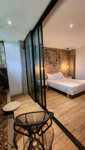 a bedroom with a bed and a table and a chair at BOURBON HOSTAL in Juayúa