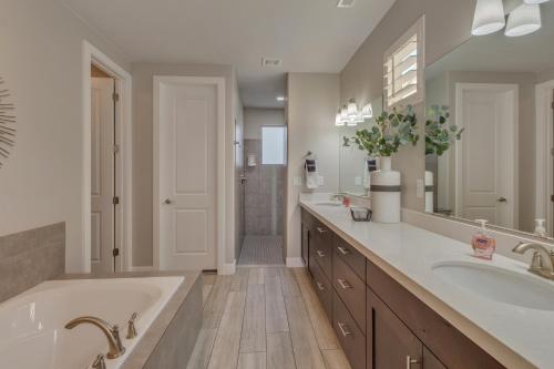 ein Badezimmer mit zwei Waschbecken und einer großen Badewanne in der Unterkunft Paradise Village Resort 86 Private Hot Tub, Game System, Community Amenities, and more in Santa Clara