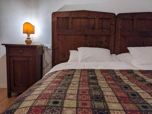 a bed with a wooden headboard and a table with a lamp at Castel San Mauro in Gorizia