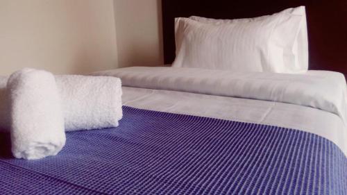 a bed with two white towels on top of it at Casa Coliving 121 in Bogotá