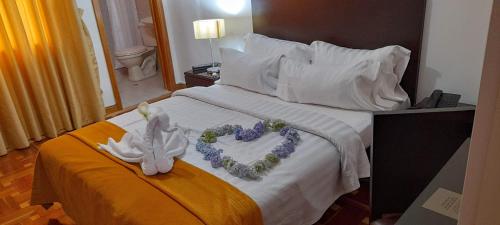 a hotel room with a bed with flowers and a valentines heart at Casa Coliving 121 in Bogotá