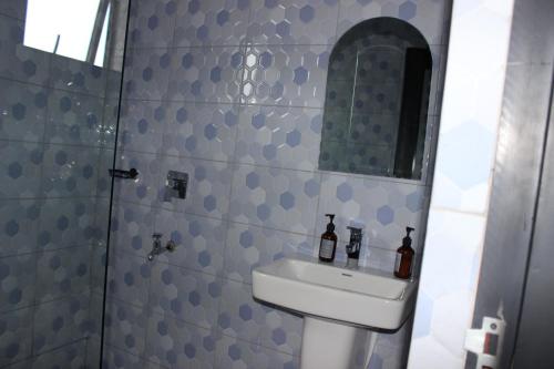 a bathroom with a sink and a mirror at MHP Apartments in Munyonyo