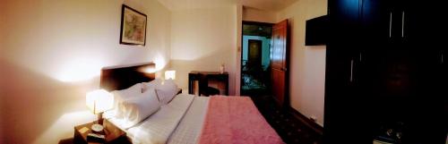 a bedroom with a bed and a table and a lamp at Casa Coliving 121 in Bogotá