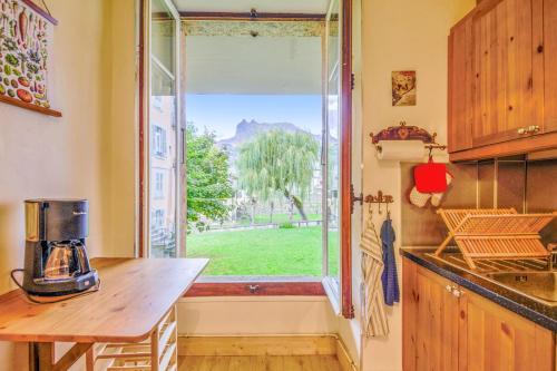 une cuisine avec une fenêtre donnant sur une cour dans l'établissement Appartement Yodel - Welkeys, à Saint-Gervais-les-Bains