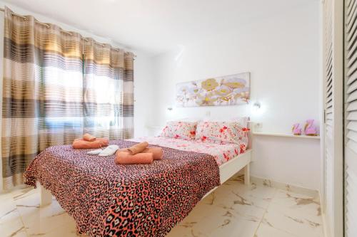 ein Schlafzimmer mit einem Bett mit zwei ausgestopften Tieren darauf in der Unterkunft Dunas of Love in Caleta de Fuste