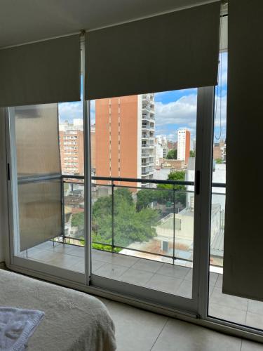 a bedroom with a large window with a view of a city at Monoambiente zona centro in Rosario