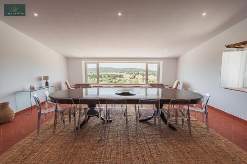 a dining room with a table and chairs and a window at Casa da Nora in Fortios