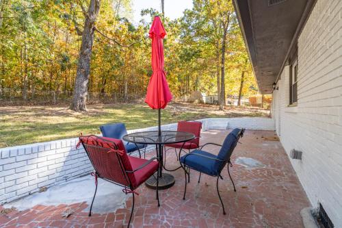 a table with chairs and an umbrella on a patio at Rustic 3BR Home in a Natural Cartersville Getaway in Cartersville