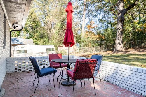 a patio with a table and chairs and an umbrella at Rustic 3BR Home in a Natural Cartersville Getaway in Cartersville