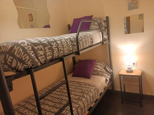 a bedroom with two bunk beds and a lamp at Habitaciones centricas en una casa Valenciana in Valencia