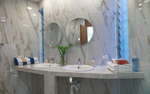 uma casa de banho com 2 lavatórios e um espelho em The Fan Villa em Port Antonio