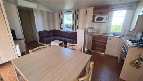 une cuisine et un salon avec une table et un canapé dans l'établissement Mobil-home 6-8pers -Clim Siblu les Charmettes, aux Mathes