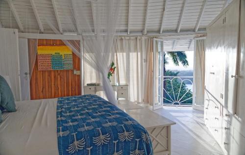 ein Schlafzimmer mit einem Bett und einem großen Fenster in der Unterkunft The Fan Villa in Port Antonio