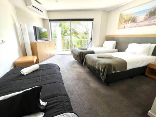 a hotel room with three beds and a couch at Peppers Salt Resort & Spa 2 br luxury spa suite in Kingscliff