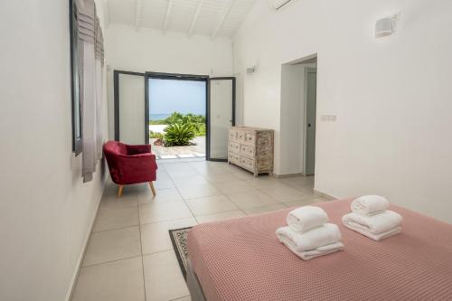 a bedroom with a pink bed with two towels on it at La Villa KAZ DEL MAR in Sainte-Anne