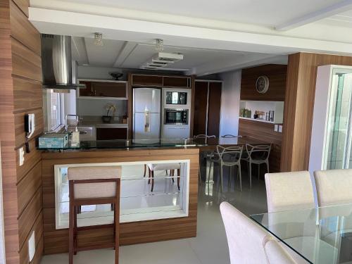 a kitchen and dining room with a glass table at Casa Maravilhosa in Tubarão