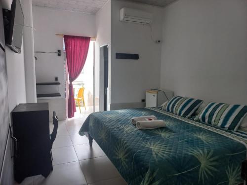 ein Schlafzimmer mit einem Bett und einem Handtuch darauf in der Unterkunft Hotel Oiti 