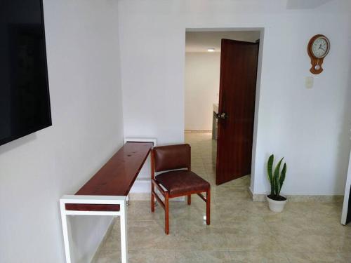 uma cadeira num quarto com uma secretária e um relógio em Apartamento acogedor confortable y céntrico para 2 em Armênia