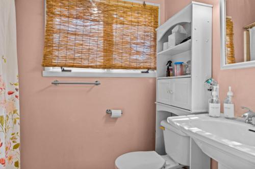 ein Bad mit einem WC, einem Waschbecken und einem Fenster in der Unterkunft Artsy Athens Oasis with spacious living area in Athens