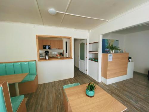 Il comprend un salon avec une table et une cuisine. dans l'établissement Indomito Sur Hostel, à Punta Arenas