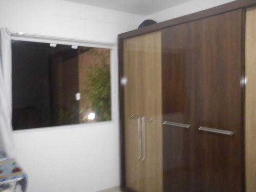 a wooden cabinet in a room with a window at Sol e Mar 850mts do mar Ingleses Satinho in Florianópolis