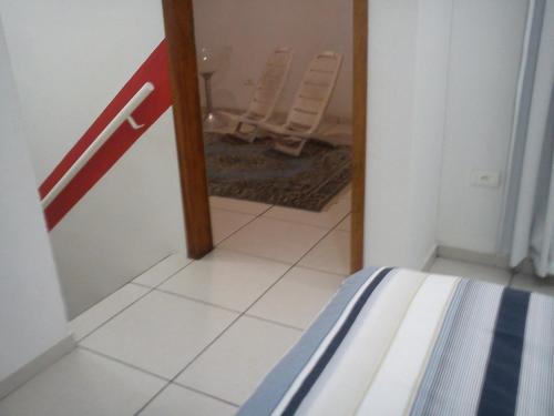 a view of a room with a mirror and a bedroom at Sol e Mar 850mts do mar Ingleses Satinho in Florianópolis