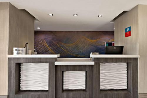 a lobby with a counter with white towels at SureStay Plus Hotel by Best Western Tulsa East in Tulsa