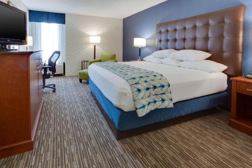 a hotel room with a large bed and a flat screen tv at Drury Inn & Suites Nashville Airport in Nashville