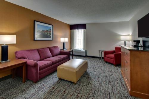 a hotel room with a couch and a table and chairs at Drury Inn & Suites Evansville East in Evansville