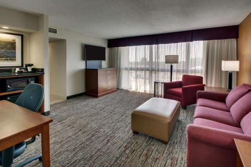 a hotel room with a couch and a chair at Drury Inn & Suites Evansville East in Evansville