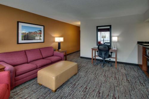 a living room with a couch and a desk at Drury Inn & Suites Evansville East in Evansville