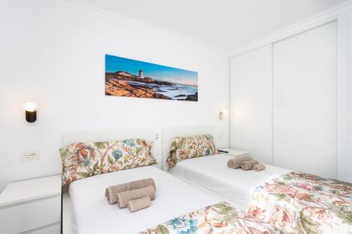 two beds in a room with white walls at Apartamento Clara in Los Cristianos
