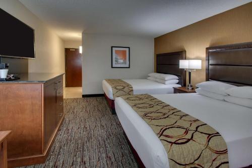 a hotel room with two beds and a flat screen tv at Drury Inn & Suites Evansville East in Evansville