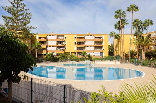 a large swimming pool in front of a building at Apartamento Clara in Los Cristianos